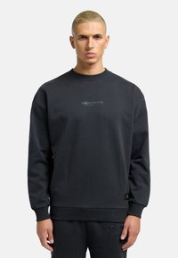 Dark gray sweatshirt with a crew neck, ribbed cuffs, and hem. Features embroidered logo on the chest and a textured accent at the waist.
