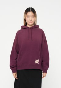 Felpa con cappuccio color bordeaux, dotata di tasca frontale e logo in basso a sinistra. Realizzata in tessuto morbido, presenta una vestibilità comoda e cordini.