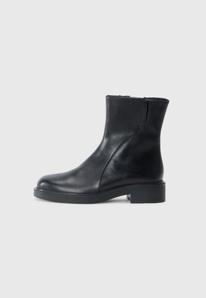 Stivali alla caviglia in pelle nera con punta arrotondata, tacco basso a blocco e design minimale. Texture liscia con sottili dettagli di cucitura.