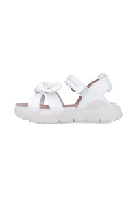 Sandalias blancas con un detalle de lazo, múltiples correas y cierre de velcro. La suela es gruesa y texturizada para mayor agarre.