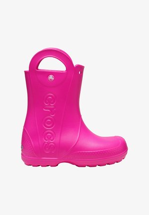 Botte de pluie en caoutchouc rose avec un bout arrondi, une semelle texturée et une poignée sur le côté. Affiche le logo "CROCS" de manière bien visible sur le côté extérieur.
