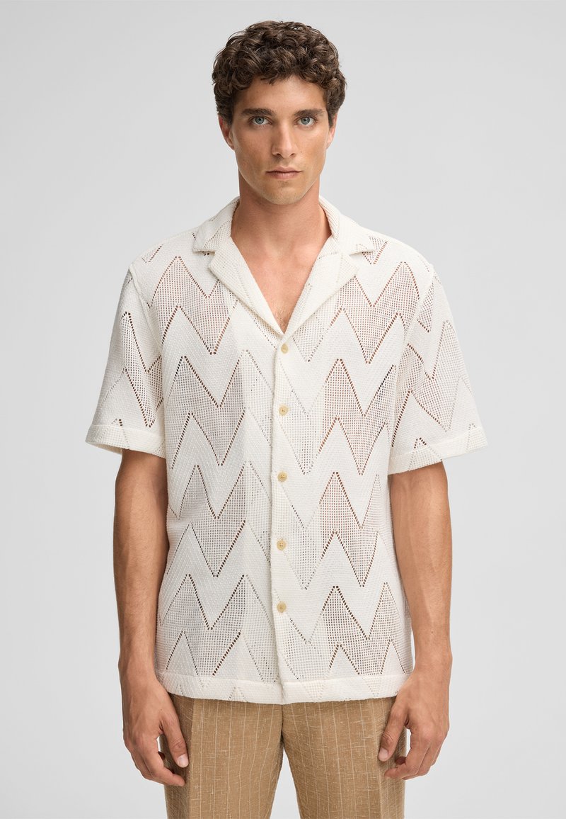 Witte korte mouwen shirt met een zigzagpatroon, gemaakt van een lichtgewicht textuurstof, met een gesneden kraag en knopen.