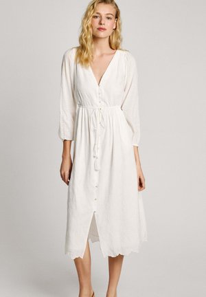 White midi dress with a V-neck, button details, drawstring waist, and eyelet pattern; long sleeves and scalloped hem. Soft cotton texture.