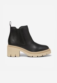 Black leather ankle boots with a beige chunky sole, elastic side panels, and a pull tab at the heel. Features a textured finish.