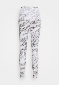 Leggings skinny en imprimé serpent blanc et gris. Tissu lisse et extensible avec une taille haute et une finition brillante. Pas de poches ni d'accents visibles.