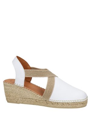 Vita lädersneaker med en vävd halmsula och beige elastiska korsettsnören. Öppen bakdesign som förbättrar andningsförmågan.