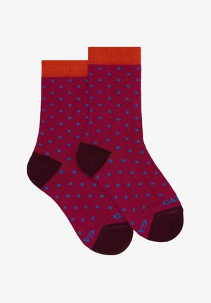 Calzini color bordeaux con polsini a coste arancioni, caratterizzati da pois blu su tutta la superficie. Accentuati da talloni e punte di un bordeaux scuro.