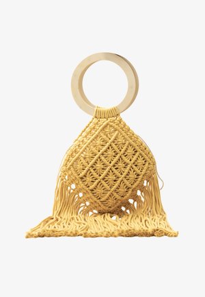 Gele macramé handtas met ronde houten hengsel en franjes aan de onderkant op een witte achtergrond.