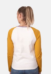 Maglietta baseball a maniche lunghe con corpo bianco e maniche giallo senape, caratterizzata da un colletto viola a contrasto e una texture liscia.