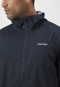 Calvin Klein Golf FEATHER DRY WATERPROOF SHELL JACKET - Regnjakke - black