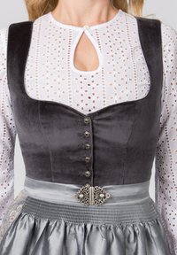Grauvelours-Bustier mit silbernen Akzenten und Knöpfen, kombiniert mit einer weißen Spitzenbluse mit Lochmustern und einem Satinklieder mit dekorativem Taillenbund.