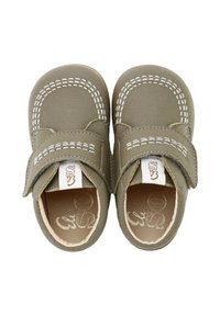 Zapatos de cuero verdes con una correa de Velcro. Acentos blancos cosidos alrededor de la zona del dedo del pie. Textura suave, punta redonda y un interior beige.