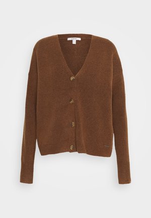 Cardigan marron en maille douce, avec col en V, manches longues et cinq gros boutons sur le devant. Petit logo en accent au bas.