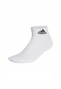 Calzini bianchi alla caviglia realizzati in misto cotone, con una fascia a coste in cima, logo Adidas nero e tre strisce nere di lato.