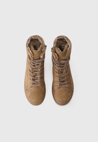 Botas de tobillo de ante marrón con cordones texturizados, puños forrados de pelo y cremalleras laterales. Diseño de puntera lisa y redondeada, y suelas de goma.