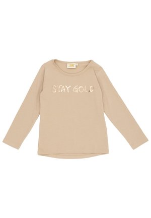 Haut beige à manches longues, à col rond, avec l’inscription « STAY GOLD » sur la poitrine.