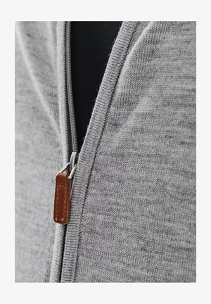 Szary dziergany kardigan zapinany na zamek z teksturowanej tkaniny, z metalowym zamkiem błyskawicznym i skórzaną pętelką w kolorze brązowym. Dopasowany dekolt, bez wzoru.