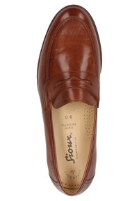 Bruine leren instappers met een gladde afwerking, ronde neus en geperforeerde inlegzool. Kenmerkt zich door decoratieve stiksels en een merklogo aan de binnenzijde.