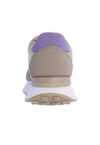 Zapatillas con una parte superior beige, acento púrpura en el talón y suela blanca. Presentan materiales texturizados y un collar acolchado para mayor comodidad.