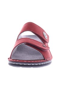 Red sandals with two fabric straps, adjustable hook-and-loop fasteners, open toe design, and a grey textured insole. Rubber sole.