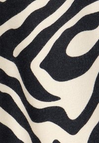 Motif abstrait de rayures zèbre en noir et blanc sur une surface de tissu texturée.