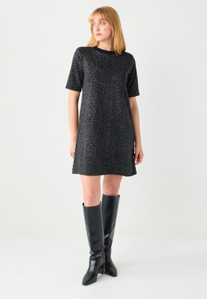 Vestito con stampa leopardata nera, maniche corte, vestibilità comoda e orlo dritto, abbinato a stivali neri lucidi al ginocchio.