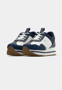 Αθλητικά παπούτσια σε ναυτικό μπλε και λευκό, με συ νδυασμό από σουέτ και πλεκτά υλικά, με στρωμένη σόλα και αντίθετες ριγέ λεπτομέρειες.