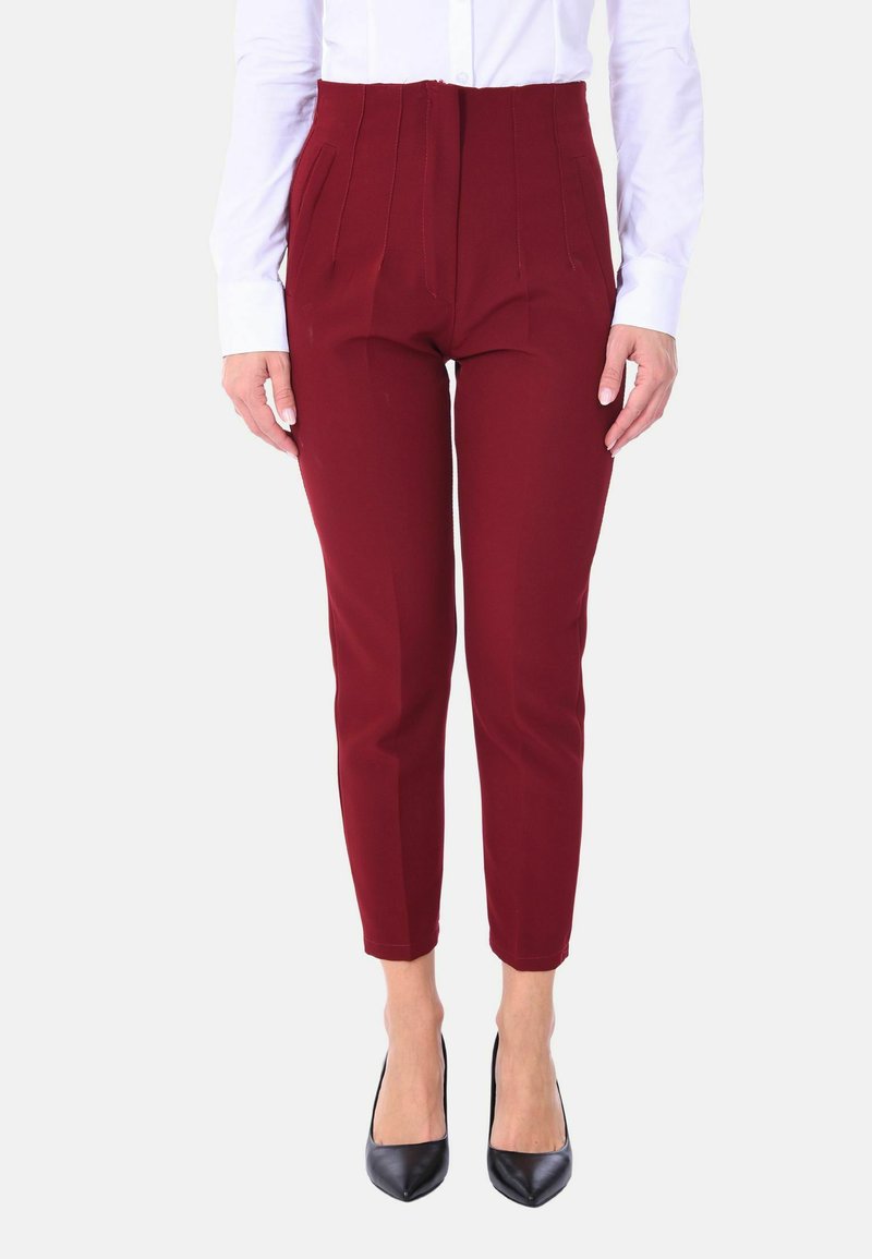 Pantaloni bordeaux su misura con fronte plissettata, design slim-fit, lunghezza cropped e texture liscia, abbinati a décolleté nere a punta.