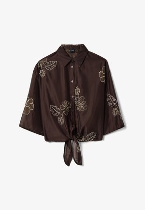 Braunes Hemd zum Knöpfen mit kurzen Ärmeln, gebundenem Saum vorne und beiger Blumenstickerei auf dem Stoff.