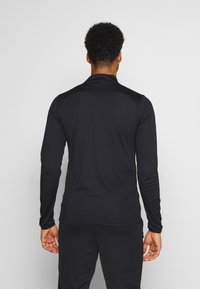 Zwarte lange mouwen shirt gemaakt van rekbaar materiaal, met een hoge kraag en een gladde textuur, ontworpen voor sportkleding.