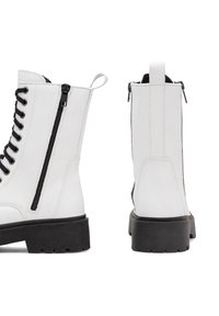 Baltas ādas kaujas zābaks ar melniem šņorēm, sānu rāvējslēdzēju un melnu tekstūru zoli. Tam ir cilpa uz papēža ērtai uzvilkšanai.