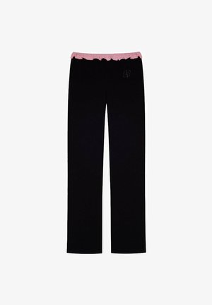 Czarne spodnie z różowym falbaniastego pasa, z subtelnym detalem z logo. Wykonane z miękkiego materiału o prostym kroju nogawki.