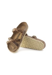Brune læder Birkenstock sandaler med flettede stropper, justerbare spænder, korkfodbede og teksturerede beige gummisåler.