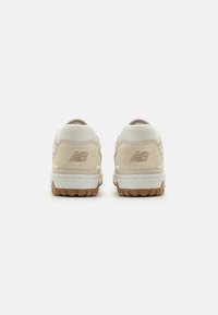 Beige Sneakers mit Obermaterial aus Wildleder und Mesh, Gummisohle und geprägtem Logo auf der Ferse. Weiße und cremefarbene Akzente heben das Design hervor.