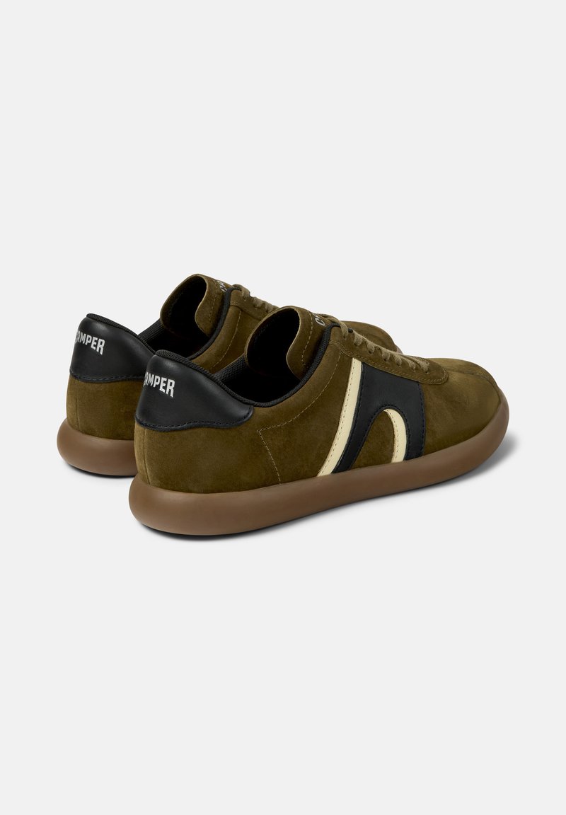 Olijfgroene suède sneakers met bruine zolen, zwarte en beige zijstrepen, zwarte hielaccenten en "Camper"-branding op de hielen.