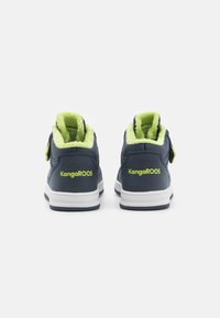 Donkerblauwe hoge sneakers met limoen groene nepbontafwerking en klittenbandsluiting, met witte zolen en "KangaROOS" branding op de achterkant.