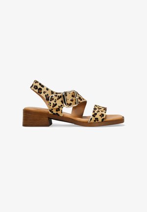 Sandalia de estampado de leopardo con un bajo tacón de madera, dos correas anchas y hebilla ajustable. Confeccionada con un material texturizado.