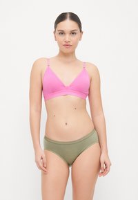 Ružový bavlnený bralet s nastaviteľnými ramienkami v kombinácii s olivovozelenými bavlnenými hipster nohavičkami. Obe majú hladkú textúru a jednoduchý dizajn.