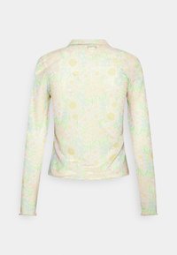 Camisola de mangas longas com gola, apresentando um padrão floral em tons pastéis sobre um fundo verde claro, feita de um tecido leve e suave.