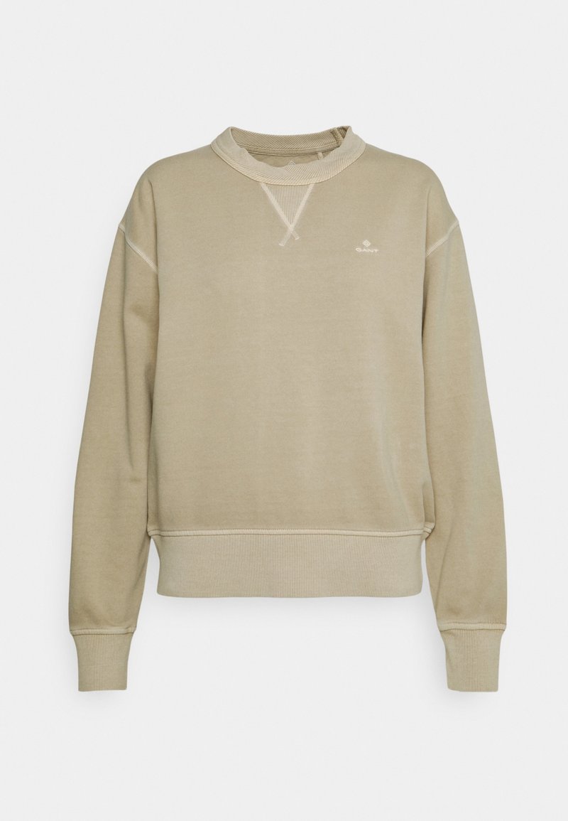 Sweatshirt beige avec un col rond côtelé, des épaules tombantes et de larges poignets. Comprend un petit logo sur la poitrine.