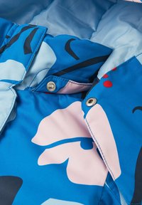 Innenfutter der blauen gemusterten Jacke mit einer glatten Textur, das große blaue und pinke abstrakte Formen zeigt, sowie silberne Druckknopf- und Knopfverschlüsse.