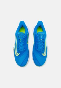 Blue athletic shoes with a textured upper, neon yellow accents, and a cushioned sole, featuring a colorful patterned detail on the heel.