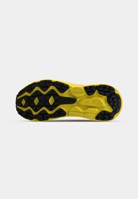 Semelle en caoutchouc texturée jaune et noire d'une chaussure de sport, conçue pour l'adhérence avec des motifs de bande de roulement multidirectionnels.