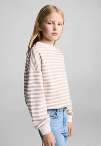 Felpa leggera a righe in morbido rosa e bianco, con collo a giro e polsini a costina, abbinata a jeans in denim azzurro chiaro.