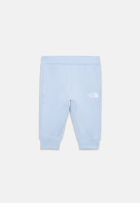 Lys blå joggebukser laget av mykt stoff, med en tettsittende midje og ankelmansjetter. Den hvite logoen er synlig på den nedre siden.