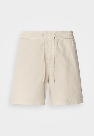 Light beige cotton shorts with an elastic waistband, drawstring closure, and side pockets. Flat-front design with simple stitching detail.