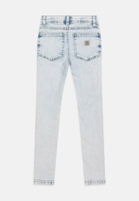 Világoskék farmernadrág, slim fit szabással, hátsó zsebekkel, logós címkével és koptatott, megviselt részekkel. A derékpánt standard magas.