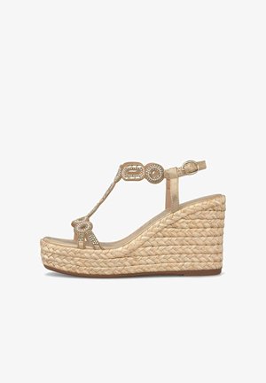 Beige sleehak sandaal met gevlochten touwzool, T-band versierd met strassteentjes en een enkelgesp sluiting.