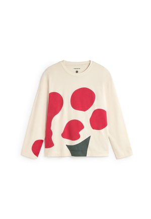 Beige pitkähihaisen topin edessä on suuria punaisia ja vihreitä abstrakteja muotoja. Pehmeästä puuvillakankaasta valmistettu, pyöreä kaula-aukko ja rento istuvuus.