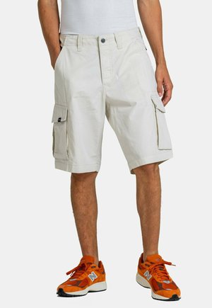 Beige cargo shorts with multiple pockets. Made of lightweight fabric, featuring a button closure and straight-cut legs.